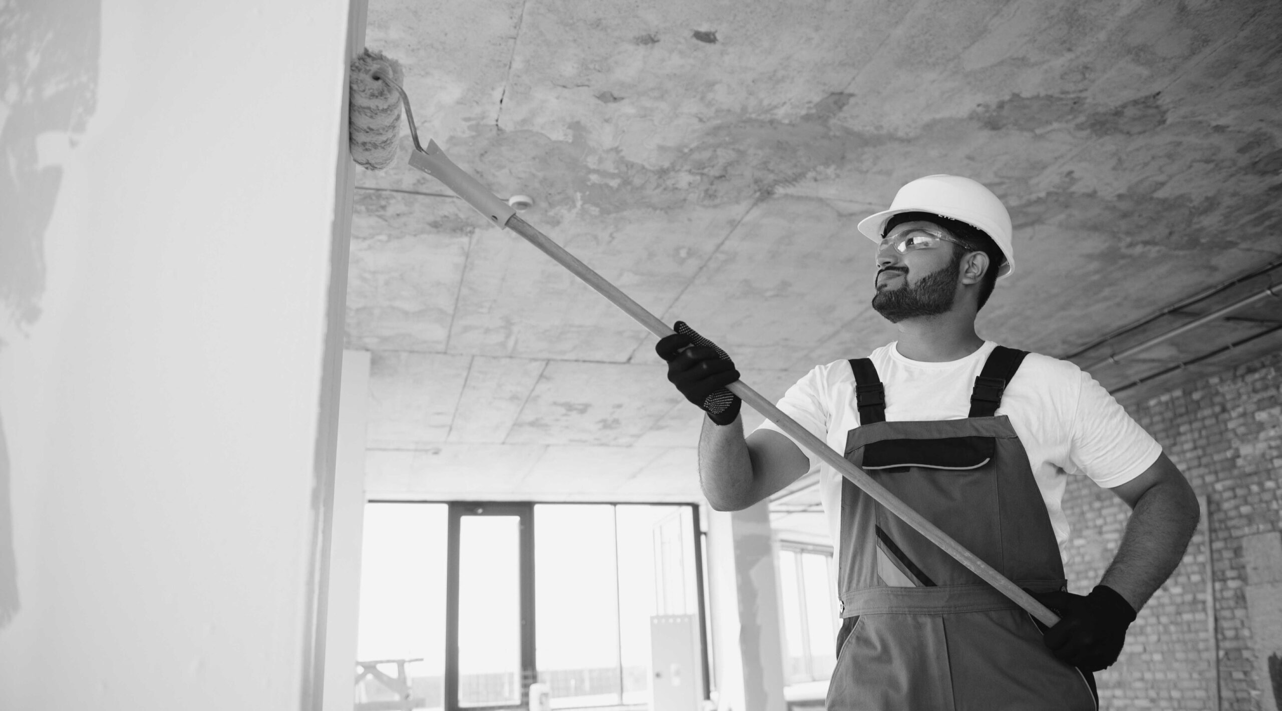 painter doing painting work on wall with roller. concept of hard working, home renovation